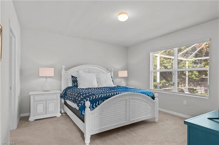 Bedroom featuring light colored carpet and baseboards
