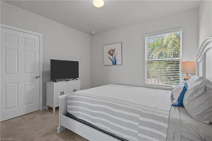 Bedroom featuring light carpet