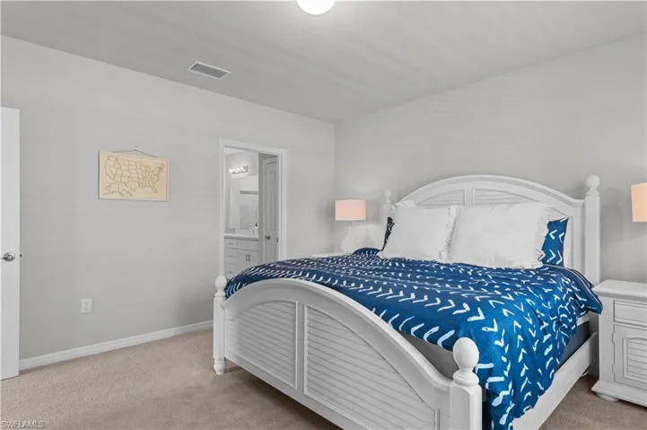 Bedroom featuring carpet floors and ensuite bath