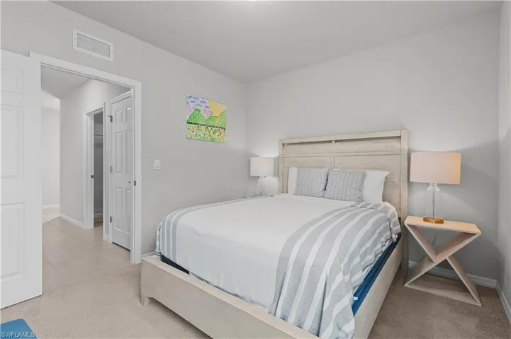 Carpeted bedroom with baseboards and tile patterned floors