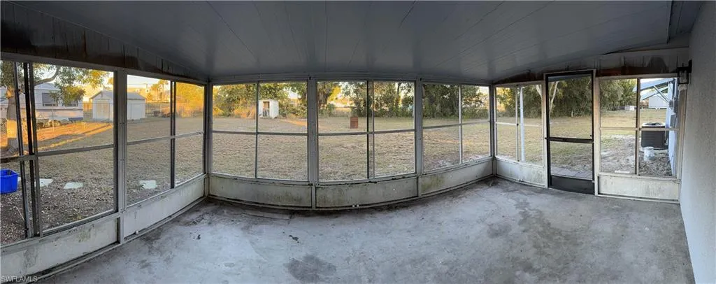 Enclosed patio featuring a screened perimeter, concrete flooring, and a screened door providing exterior access