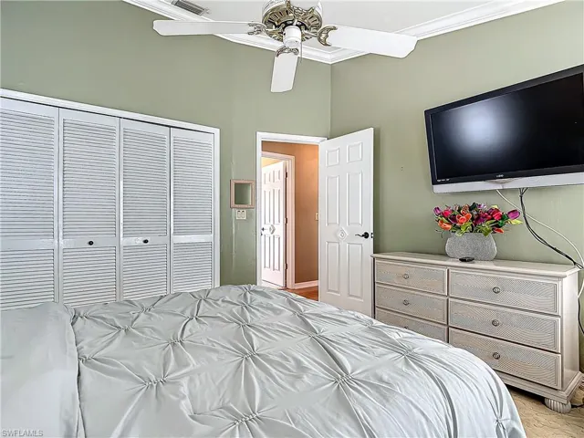 Bedroom featuring a ceiling fan, ornamental molding, and a closet