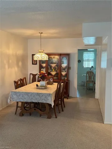 Dining area with carpet and a textured ceiling