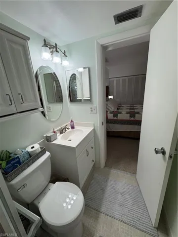 Ensuite bathroom with vanity and light tile patterned flooring