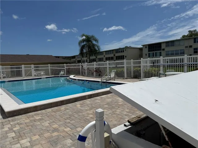 Community pool with a patio and a residential view
