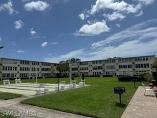View of home's community with shuffleboard and a lawn