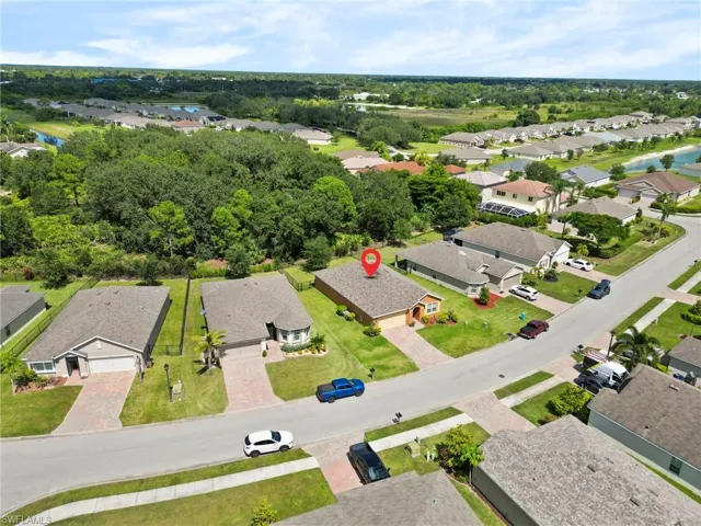 Aerial view of property and surrounding area featuring nearby suburban area