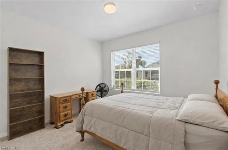 Bedroom with light carpet and baseboards