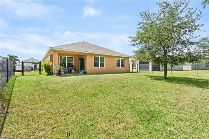 Rear view of property with a fenced backyard, a gate, stucco siding, and a shingled roof