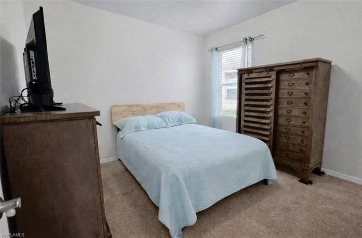 Bedroom with carpet floors and baseboards
