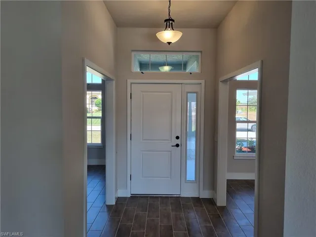 Foyer entrance with healthy amount of natural light and wood finish floors