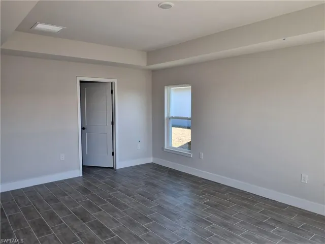 Spare room with baseboards and wood finish floors