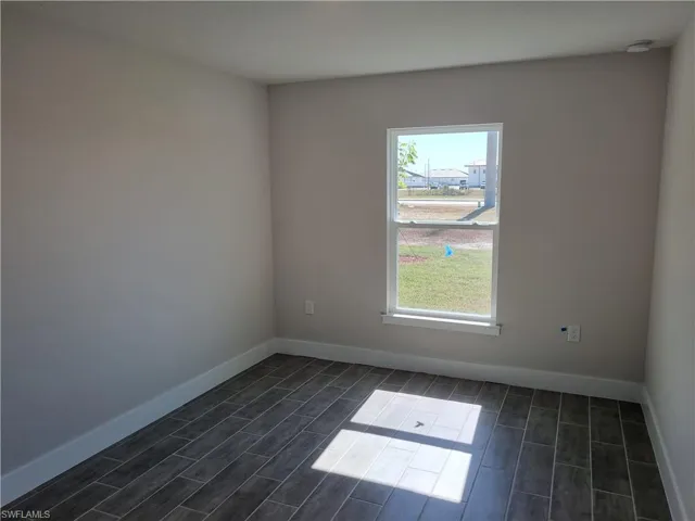 Spare room with baseboards and wood tiled floors
