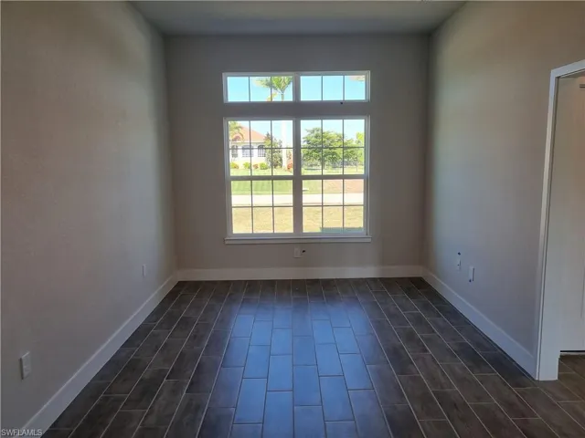 Spare room with baseboards and wood tiled floors