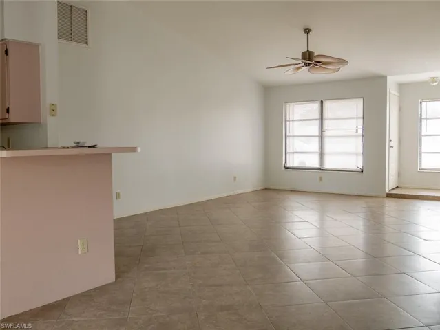 Empty room with light tile patterned flooring and ceiling fan