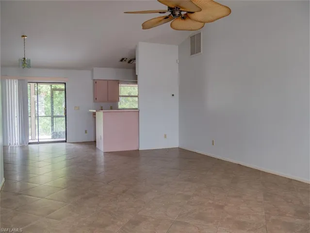 Unfurnished living room with a ceiling fan and baseboards