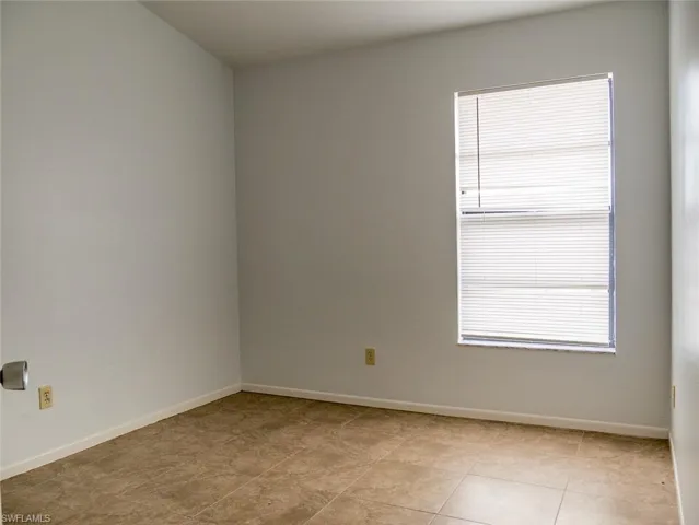 Unfurnished room featuring baseboards and light tile patterned floors