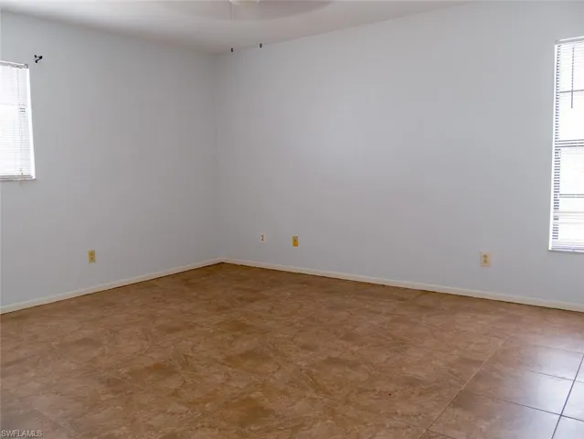 Spare room with baseboards and a ceiling fan