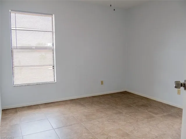 Spare room with baseboards and light tile patterned floors