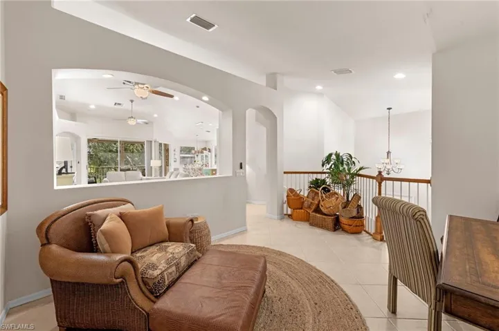 Living area with light tile patterned floors, recessed lighting, ceiling fan, a chandelier, and lofted ceiling