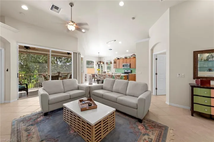 Living area featuring light tile patterned floors, recessed lighting, a ceiling fan, and arched walkways