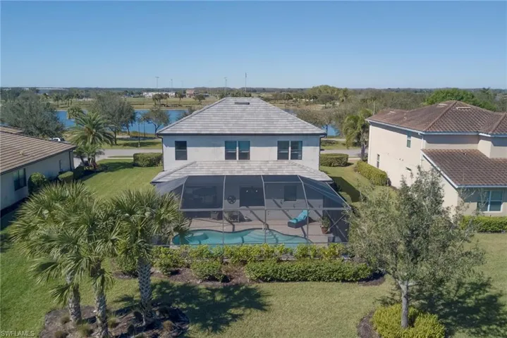 Back of property featuring a lanai and an outdoor pool