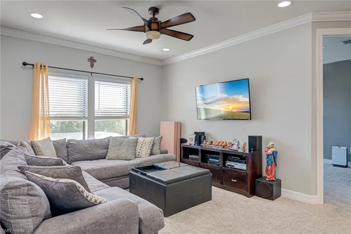 Loft room featuring ornamental molding, carpet, ceiling fan, and recessed lighting