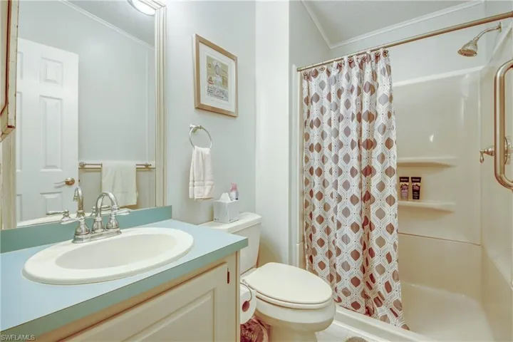 Full bath featuring crown molding, a shower stall, vanity, and a textured ceiling