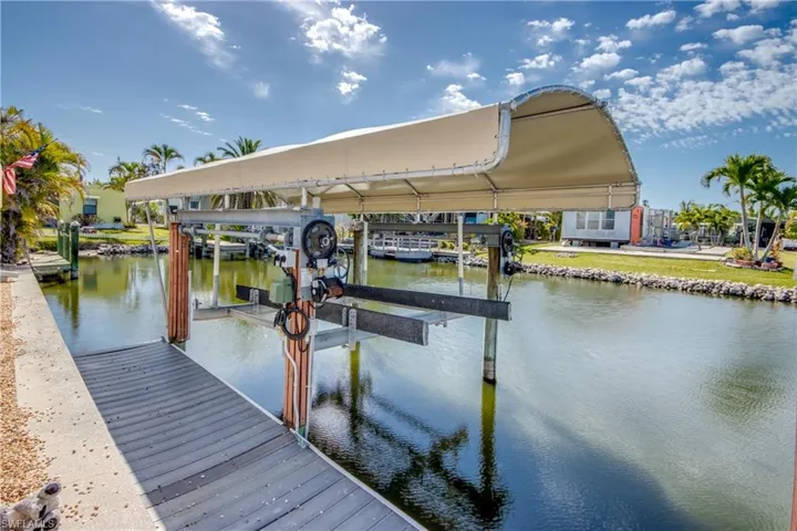 Dock area featuring boat lift and a water view
