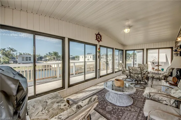 Sunroom / solarium with a water view and lofted ceiling