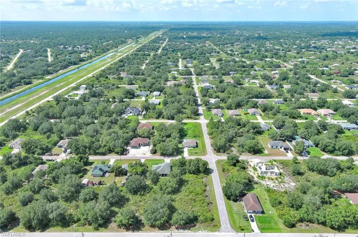 Aerial view of property and surrounding area with a nearby body of water and nearby suburban area