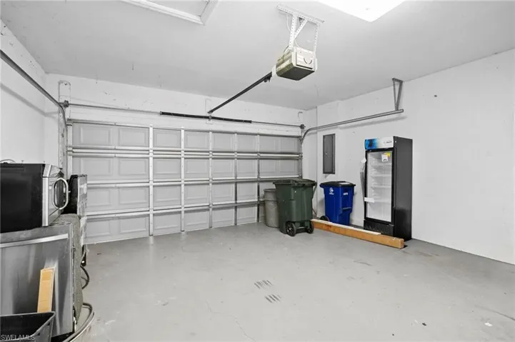 Garage featuring a garage door opener and electric panel