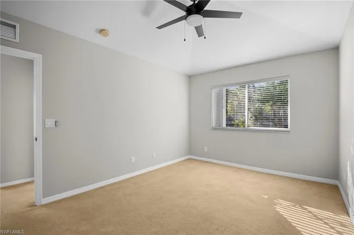 Unfurnished room featuring light carpet, ceiling fan, and lofted ceiling