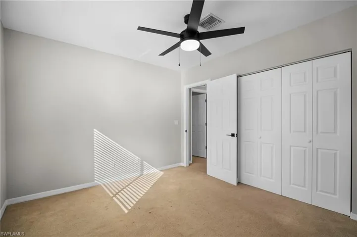 Unfurnished bedroom featuring carpet floors, a closet, and a ceiling fan