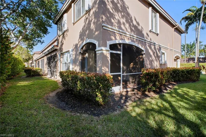 View of home's exterior featuring a lawn, stucco siding, and a sunroom