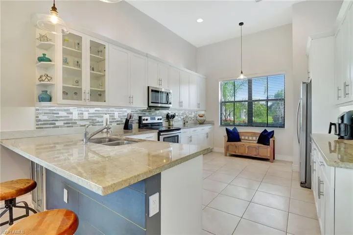 Kitchen features white custom wood cabinets, kitchen nook, ss appliances, sand color granite, custom tile backsplash, above & below custom "mood" lighting.