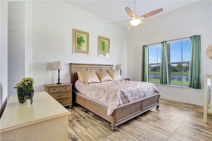 Master bedroom with light laminate floors with view of lake