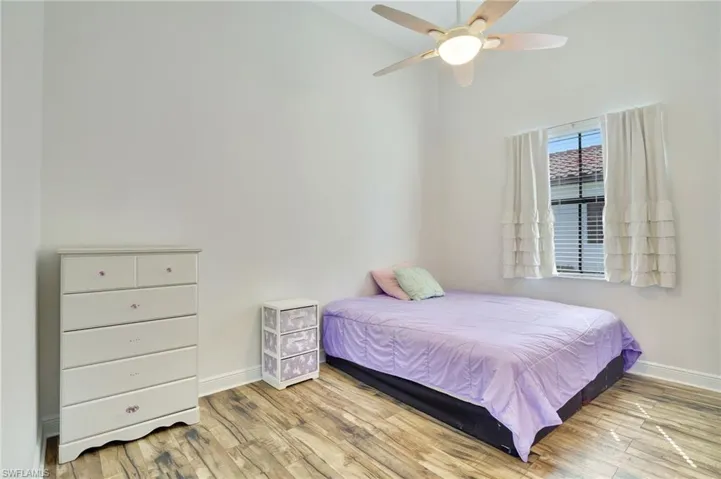 Bedroom #2 featuring light laminate wood-style flooring and ceiling fan
