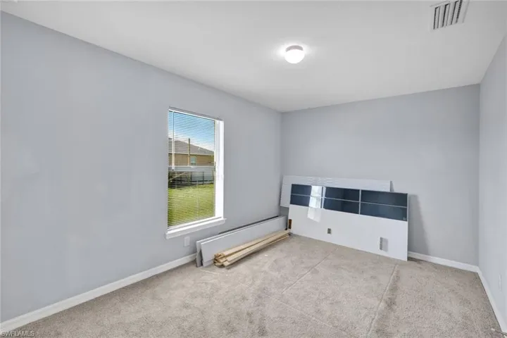 Carpeted empty room with baseboards