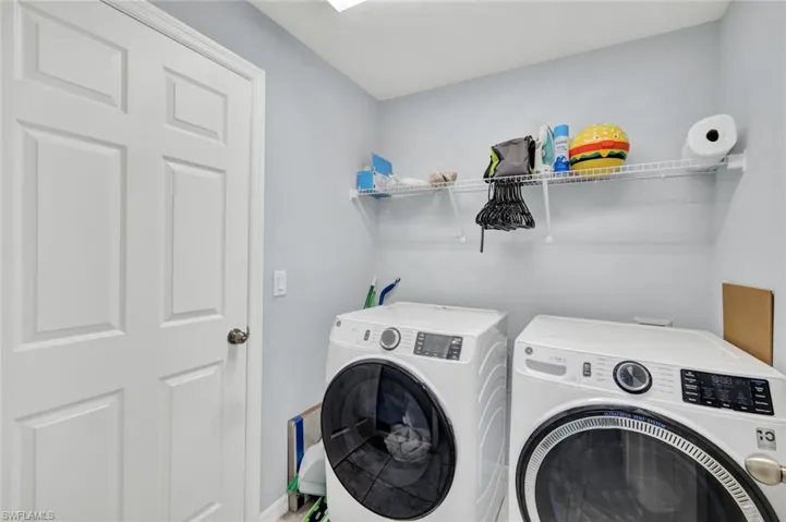 Washroom with washer and dryer and baseboards