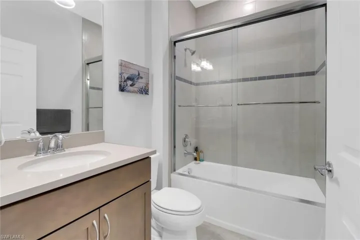 Full bathroom featuring vanity, toilet, and enclosed tub / shower combo