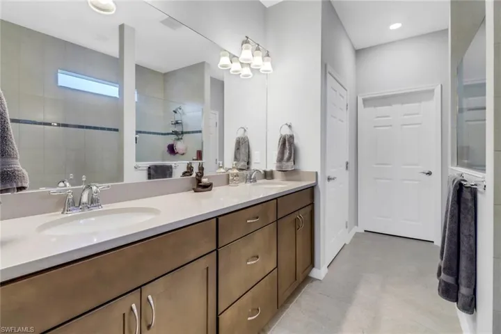 Bathroom featuring vanity and tiled shower