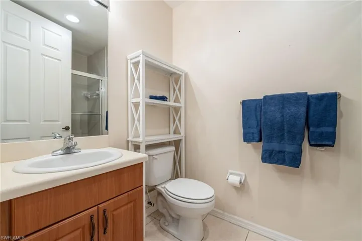 Bathroom with a shower stall, vanity, and light tile patterned flooring