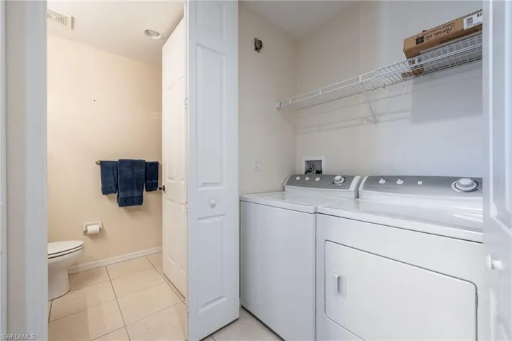 Laundry area featuring light tile patterned flooring and independent washer and dryer