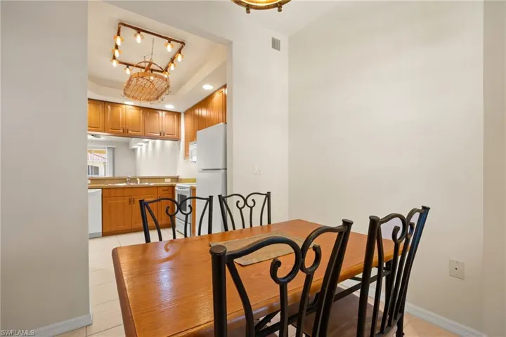 Dinette in Breakfast Room featuring hanging lights, a raised ceiling, and light tile patterned floors