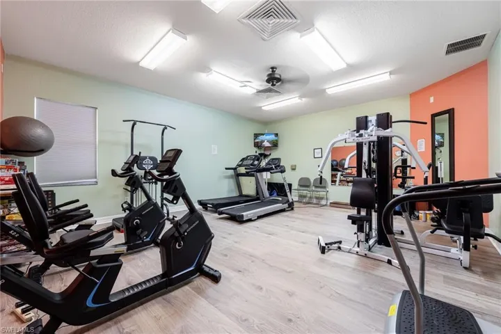 Exercise room featuring ceiling fan and a textured ceiling