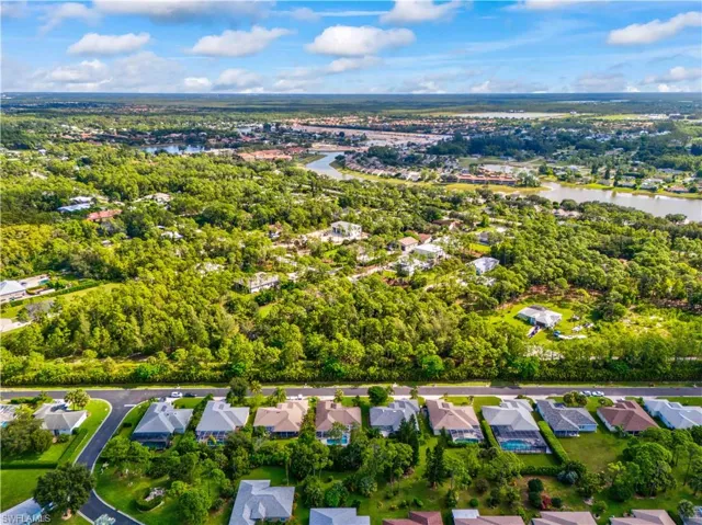 Aerial view of property and surrounding area with a large body of water and nearby suburban area