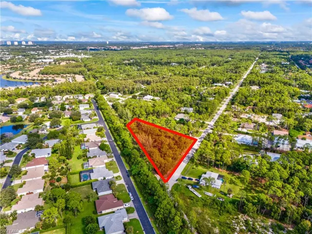 Aerial view of property's location featuring nearby suburban area, property boundaries highlighted, and a large body of water