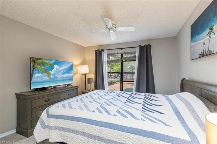 Bedroom with access to exterior, carpet, a ceiling fan, and a textured ceiling