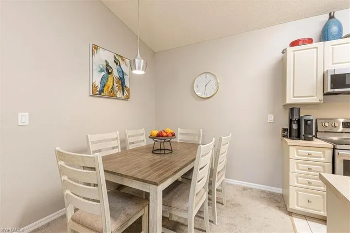 Dining area featuring light colored carpet and a textured ceiling